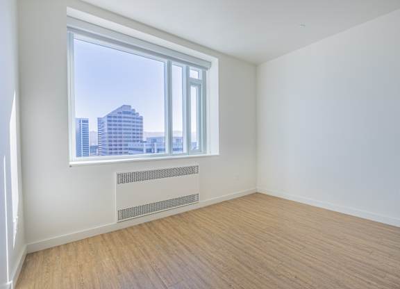 A room with a window overlooking a cityscape.