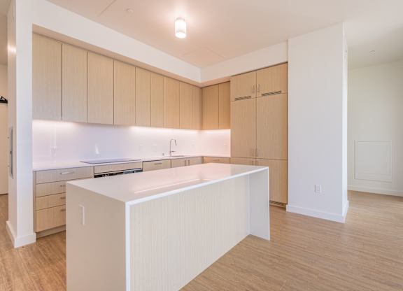 A kitchen with wooden cabinets and a white island.