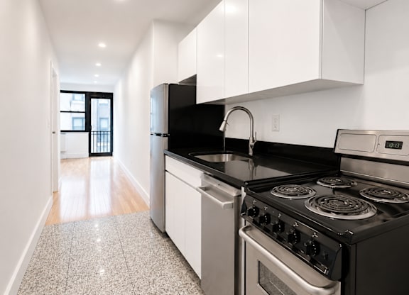 A kitchen with black countertops and white cabinets.