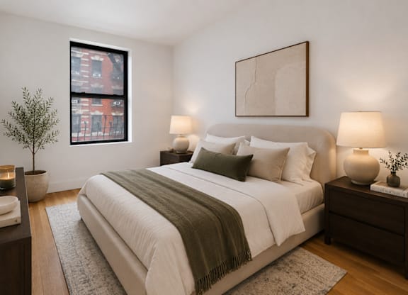 A bedroom with a large bed, two lamps, and a small tree.