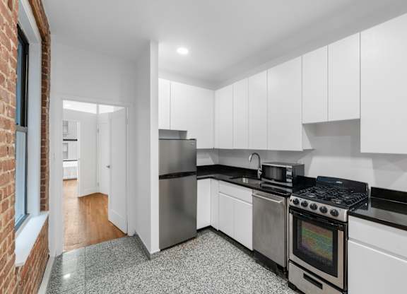 A kitchen with white cabinets and a black stove top.