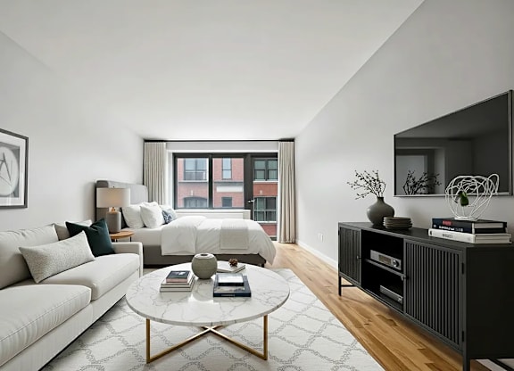 A modern living room with a white sofa, a coffee table, and a large window.