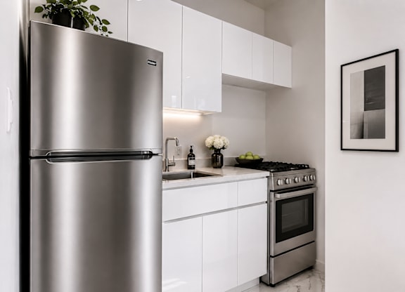 A modern kitchen with a stainless steel refrigerator and oven.