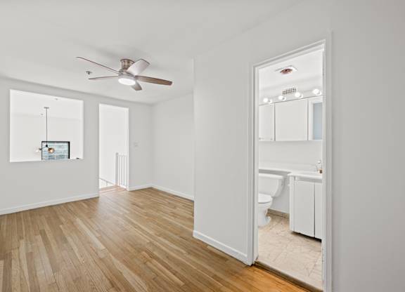 A room with a ceiling fan and a mirror on the wall.