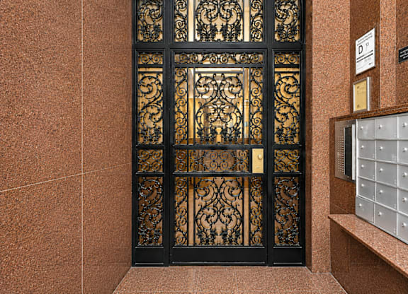 A brown wall with a decorative window and a mailbox.