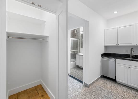 A kitchen with white cabinets and a refrigerator.