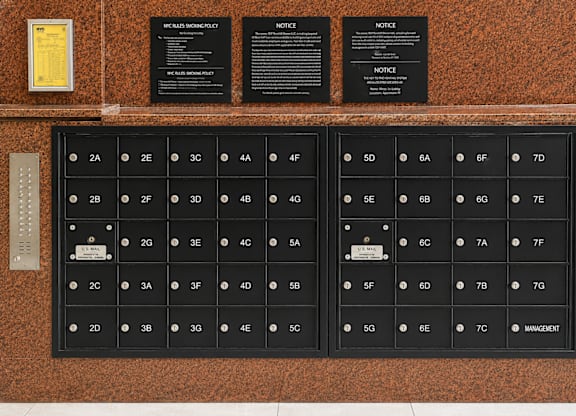 A wall with a series of black plaques and a keypad with numbers and letters.