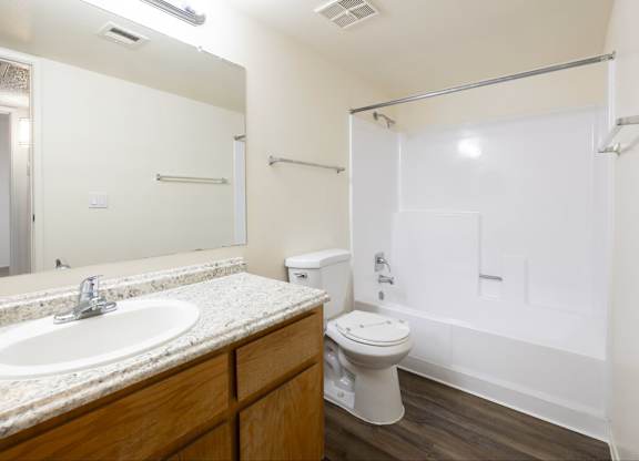 A white bathroom with a toilet, sink, and shower.