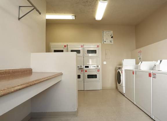 A laundry room with washers and dryers.