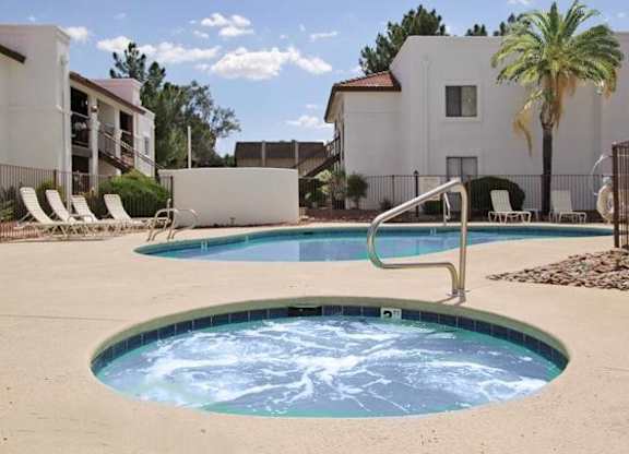 A hot tub sits in the middle of a pool surrounded by chairs.