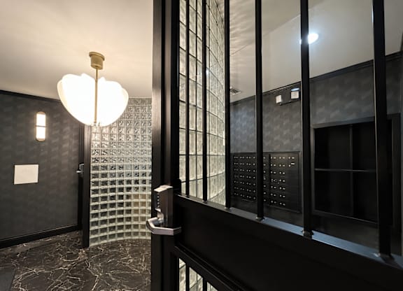 A bathroom with a black and white tiled wall and floor.