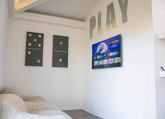 A bedroom with a bed and a television mounted on the wall.