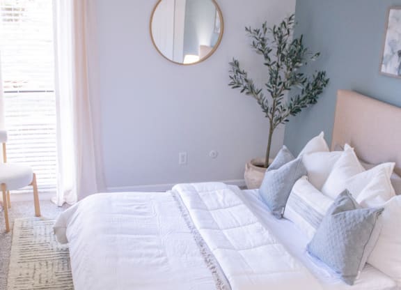 a bedroom with a bed and a mirror on the wall