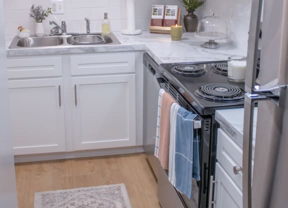 a white kitchen with stainless steel appliances and white cabinets
