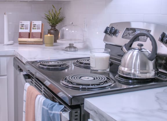 a small kitchen with a stove and a kettle on the stove