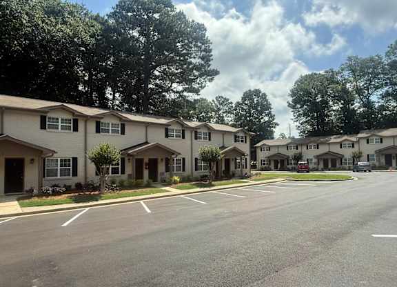 A row of houses with trees in the background at Waverly Manor Townhomes, Norcross, GA 30071