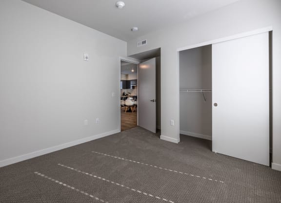 a living room with a carpet and a door to a closet at Sagecrest Apartments, Wenatchee, WA