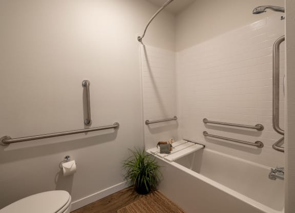 a bathroom with a tub and a toilet and a plant at Sagecrest Apartments, Wenatchee, 98801