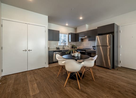 a kitchen with stainless steel appliances and a table and chairs at Sagecrest Apartments, Washington
