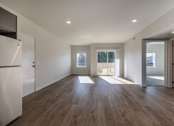 Living room with white walls and wood flooring at Sagecrest Apartments, Washington