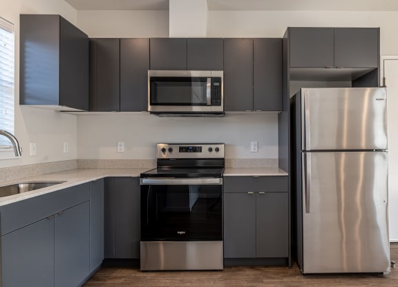a kitchen with stainless steel appliances and black and silver cabinets at Sagecrest Apartments, Wenatchee, Washington