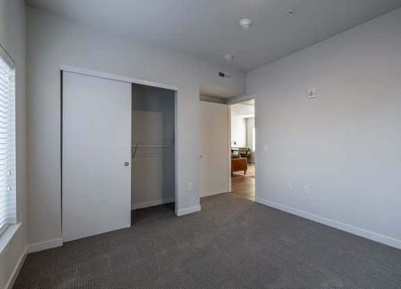 a bedroom with a closet and a door to a living room at Sagecrest Apartments, Wenatchee, WA, 98801