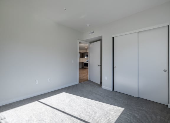 a living room with white walls and white closet doors at Sagecrest Apartments, Wenatchee, WA