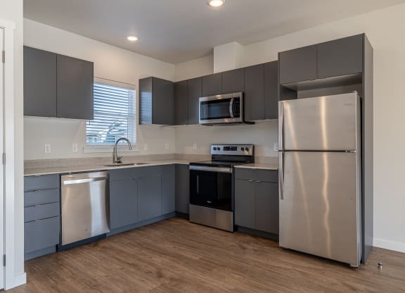 kitchen with stainless steel appliances and gray cabinets at Sagecrest Apartments, Wenatchee, 98801