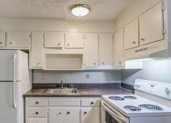 A kitchen with white appliances and cabinets.at Waverly Manor Townhomes, Norcross, 30071  