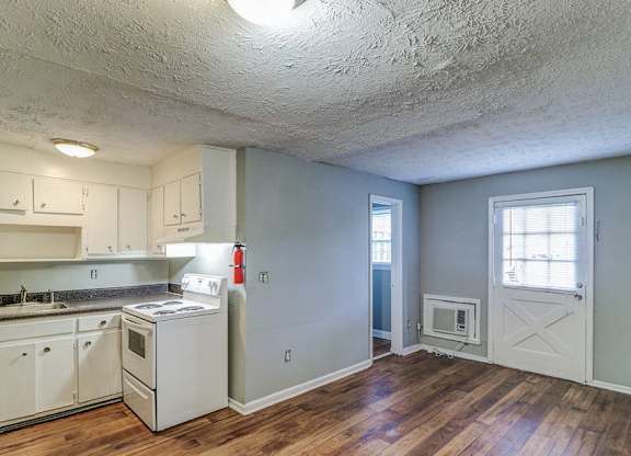 A kitchen with white cabinets and a wood floor.at Waverly Manor Townhomes, Norcross, GA 30071  