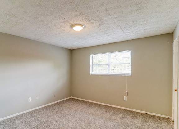 A room with a window and a carpeted floor.at Waverly Manor Townhomes, Georgia, 30071