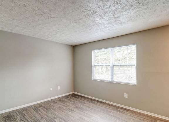 A room with a window and wooden flooring.at Waverly Manor Townhomes, Norcross Georgia  