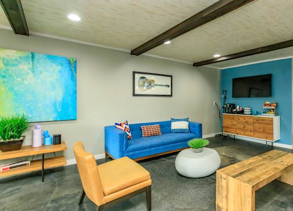 A living room with a blue couch and a wooden coffee table.