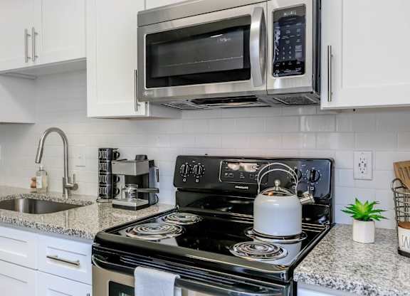 A black stove top oven with a kettle on it.