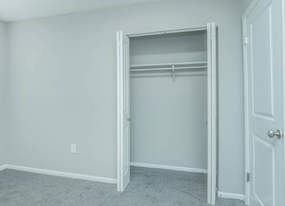 A white closet with a door open and a carpeted floor at Crest at East Cobb Apartments, Marietta, GA, 30062