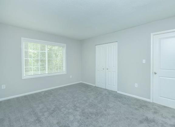 A room with a carpeted floor and two doors at Crest at East Cobb Apartments, Marietta