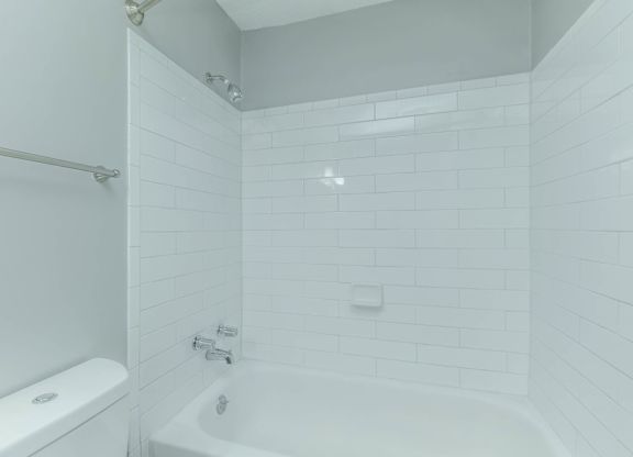 A white bathroom with a tub, toilet and shower at Crest at East Cobb Apartments, Marietta, GA