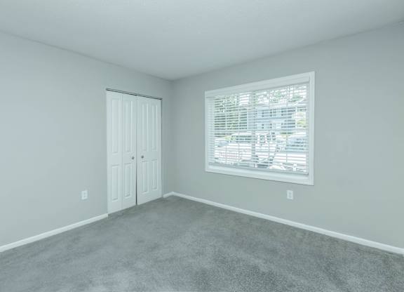 A room with a carpeted floor and a window with blinds at Crest at East Cobb Apartments, GA, 30062