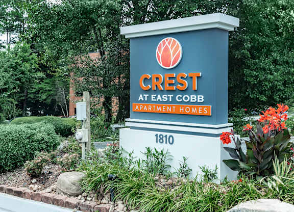 A sign for Crest at East Cobb Apartment Homes is shown in front of a landscaped area at Crest at East Cobb Apartments, Marietta, Georgia