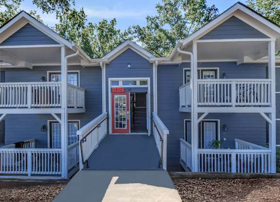 A small building with a red door and white railings at Crest at East Cobb Apartments, Marietta, GA