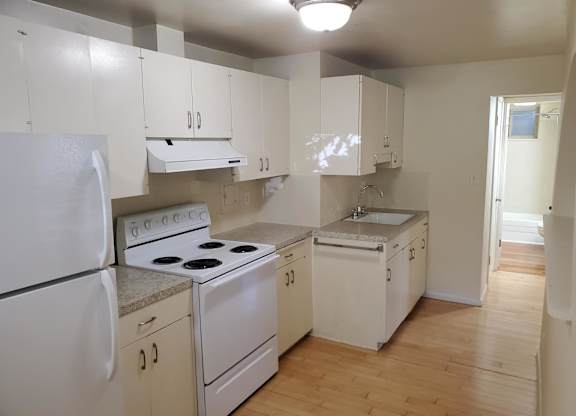A kitchen with white appliances and cabinets.