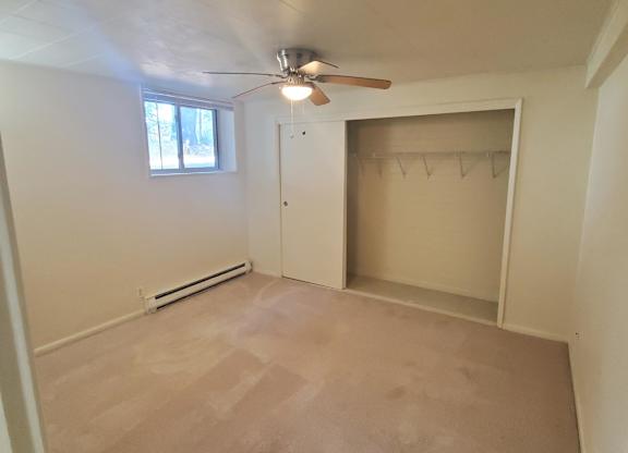 A room with a ceiling fan and a window.