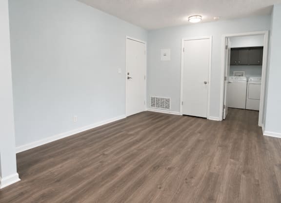 A room with wood flooring and white walls.