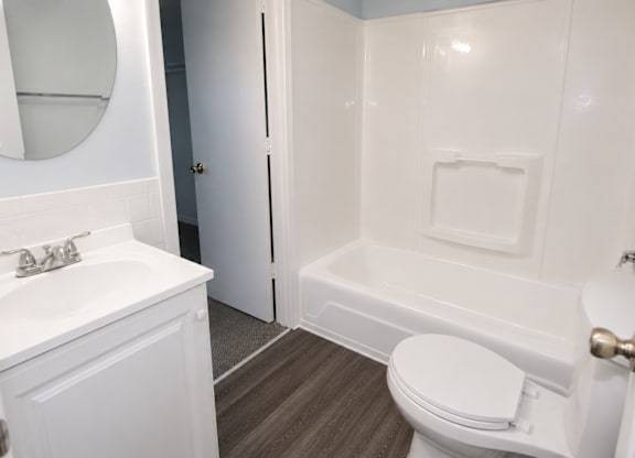 A white bathroom with a toilet, sink, and bathtub.