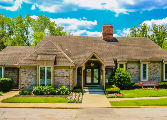 a small brick house with a bench in front of it