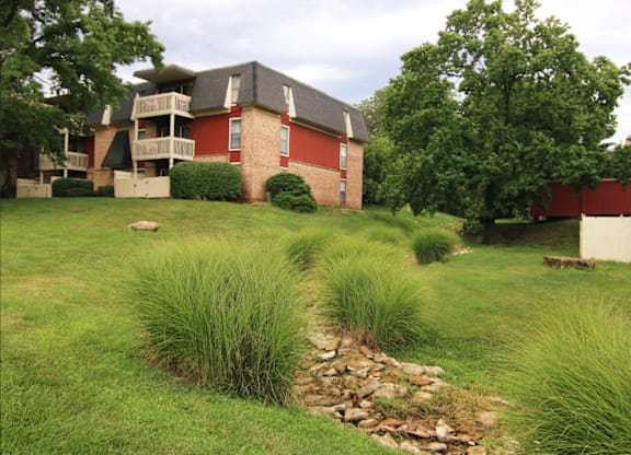 A grassy area in front of a red building.