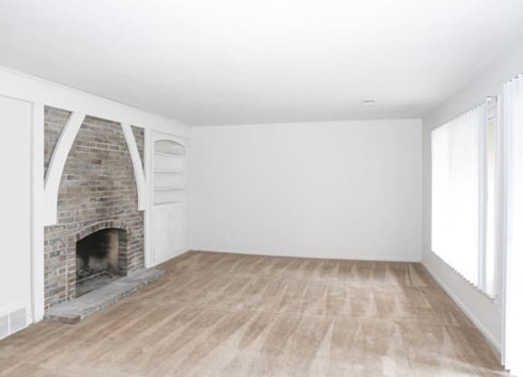 Living Room with fireplace and built-in shelves at Canyon Creek Apartments, Missouri