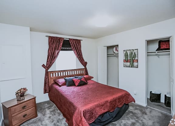 a bedroom with a bed and a dresser and a window at Gatehouse Apartments, Missouri