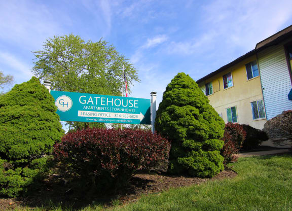 a building with a gatehouse sign in front of bushes and trees at Gatehouse Apartments, Kansas City, MO, Missouri