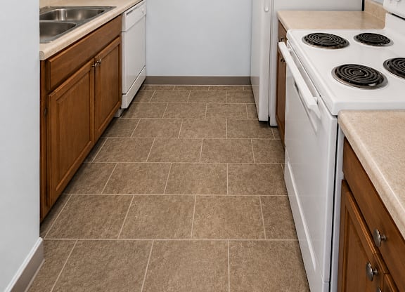 A kitchen with a white stove top oven and a white refrigerator.